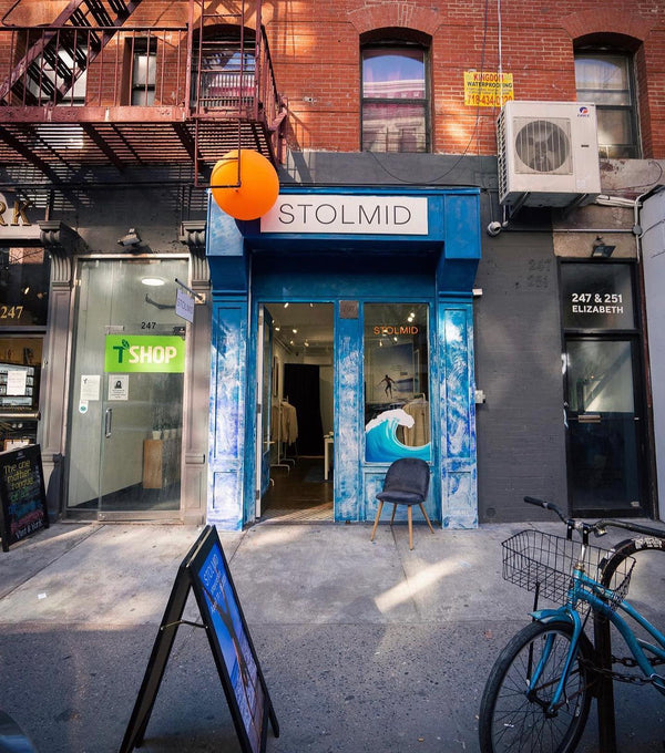 An image of the Stolmid Storefront. The balloon mimics the shorts and shirts with the orange button and circle.